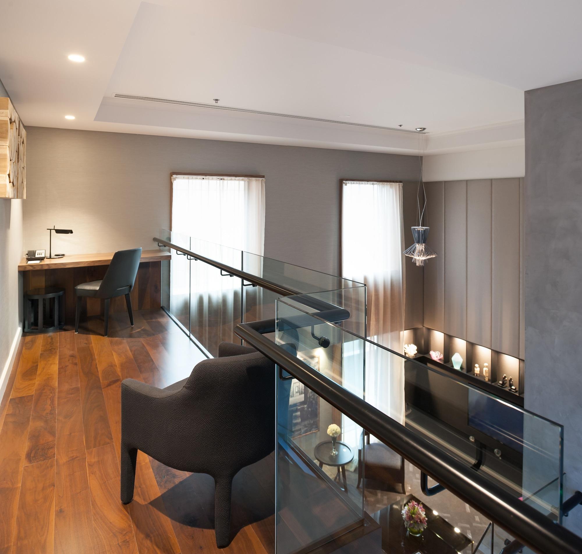 Hotel Stamford Plaza Melbourne City Exterior foto The photo shows a modern interior space, featuring a second-floor balcony overlooking a lower level. The decor is stylish and minimalistic, with a combination of wooden flooring and neutral-colored walls. 

On the upper level, there is a small desk a