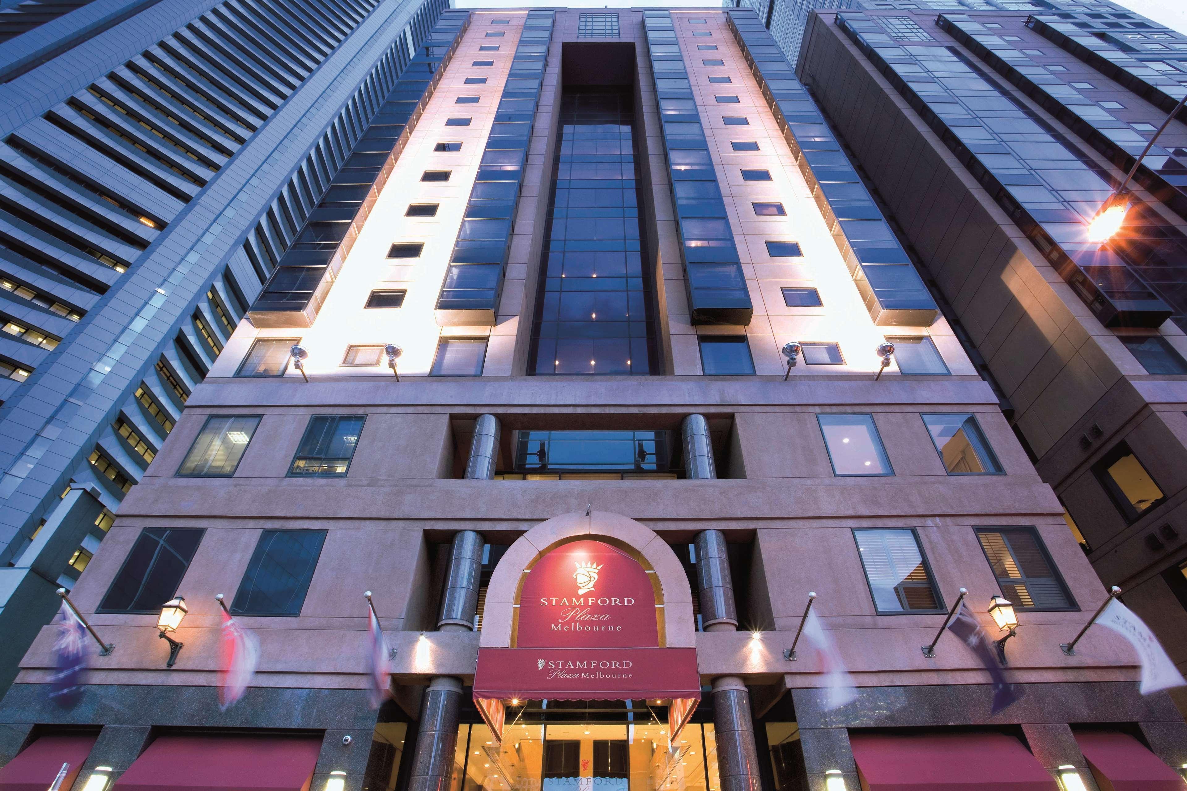 Hotel Stamford Plaza Melbourne City Exterior foto The photo shows the exterior of a modern hotel building. The structure appears tall and features a combination of glass and stone elements. Large windows are prominent, particularly in the center section, which suggests a contemporary architectural s