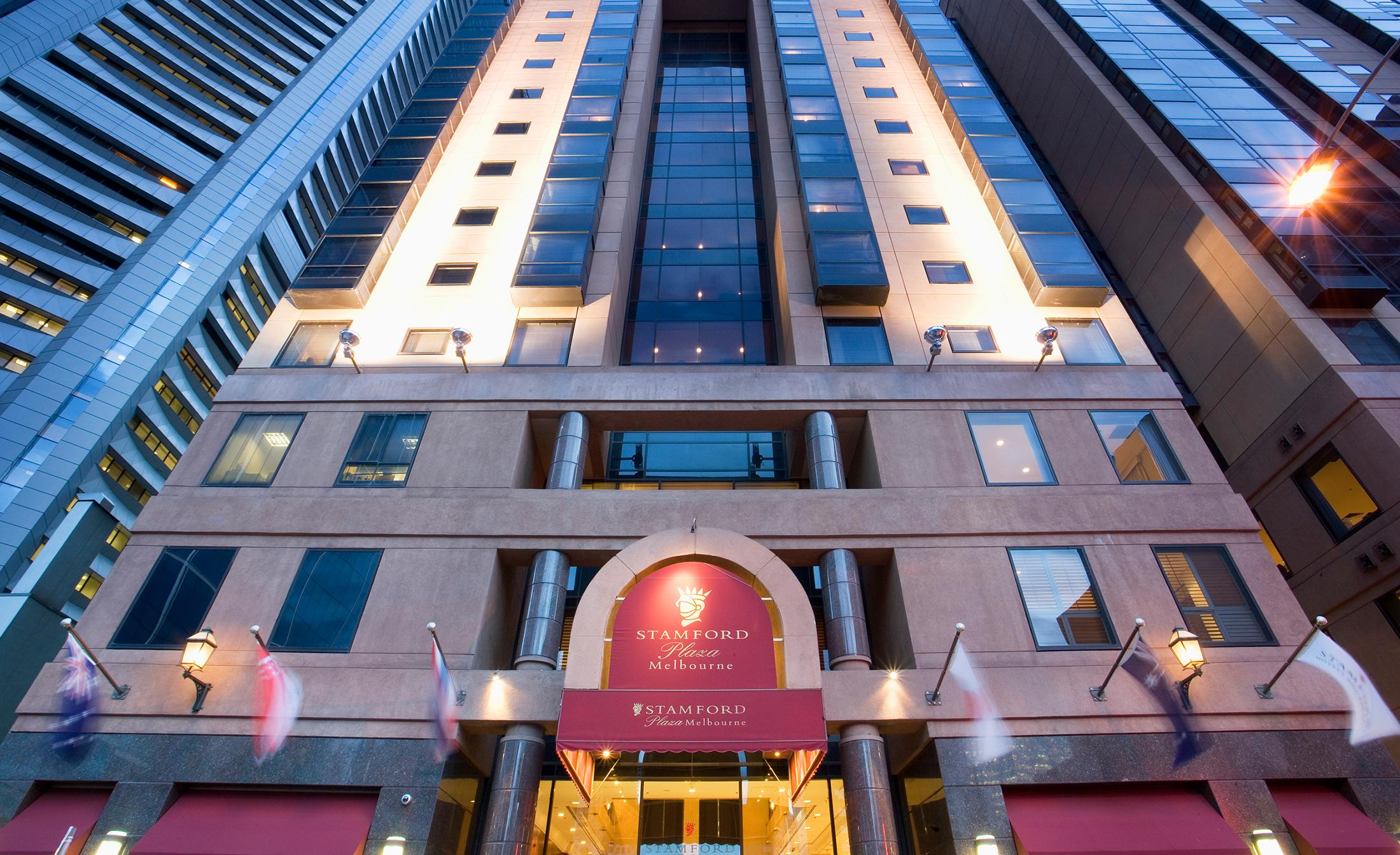 Hotel Stamford Plaza Melbourne City Exterior foto The photo shows the entrance of a modern hotel building. The architecture features a tall structure with glass and stone elements. The hotel's name is visible above the entrance, which is framed by an arch, and the facade includes multiple levels wit