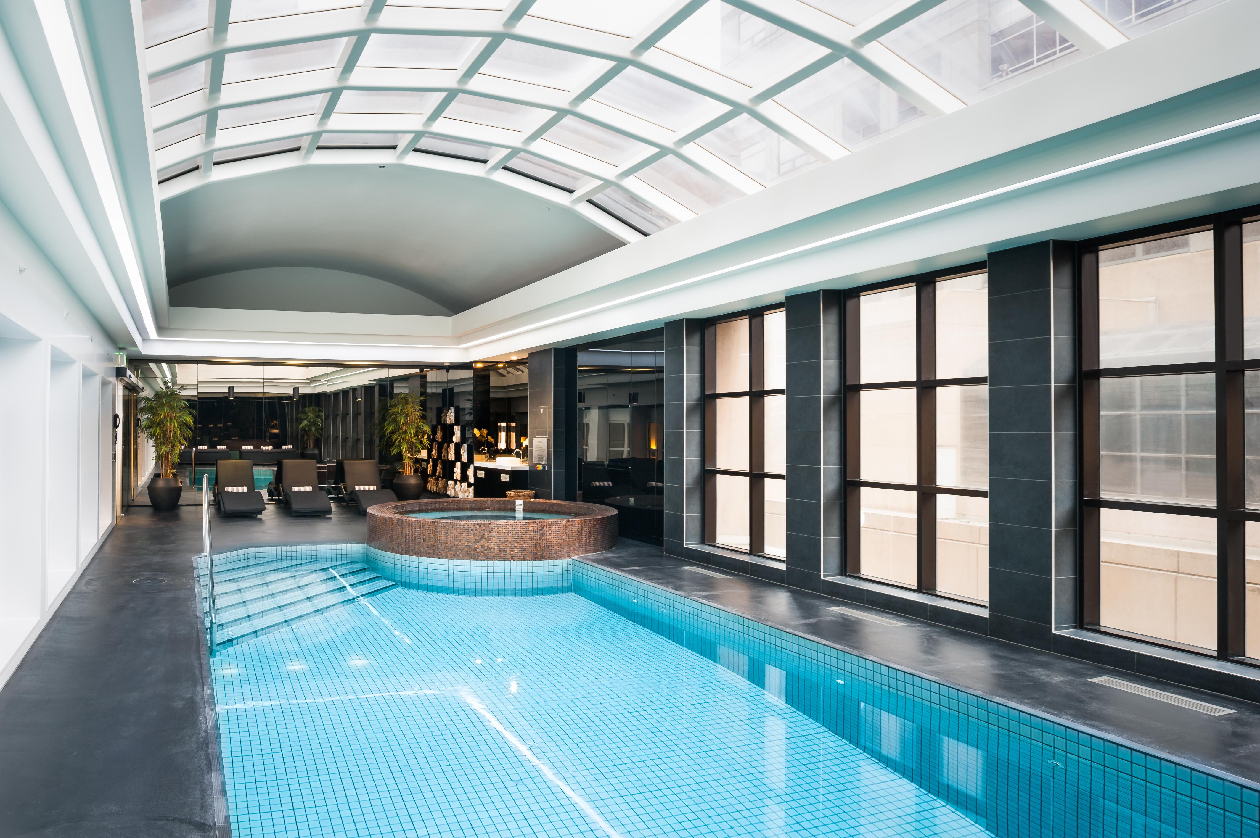 Hotel Stamford Plaza Melbourne City Exterior foto The photo shows an indoor swimming pool area with a modern and sleek design. The pool is rectangular and features bright blue tiles. Above the pool, there's a large, transparent glass ceiling that allows natural light to flood the space. Surrounding 