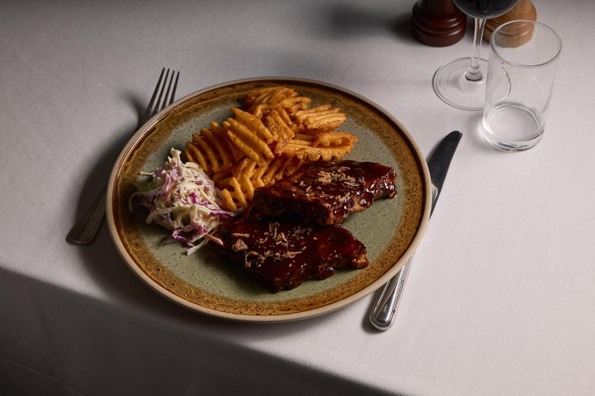 Hotel Stamford Plaza Melbourne City Exterior foto The photo displays a plate of food featuring two pieces of steak that appear to be glazed with a rich sauce. Alongside the steak, there are crinkle-cut fries arranged neatly on one side of the plate. Additionally, there's a small serving of coleslaw,