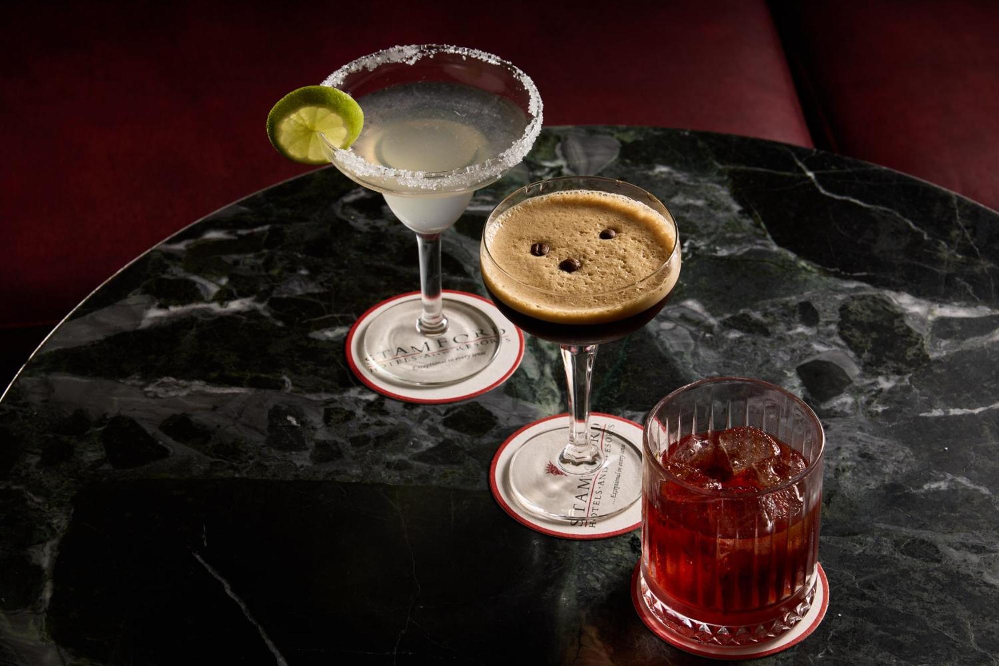 Hotel Stamford Plaza Melbourne City Exterior foto The photo features three different cocktails displayed on a dark, marble table. 

1. **Left Cocktail**: A margarita served in a traditional glass, garnished with a lime wedge and featuring a salted rim.
2. **Middle Cocktail**: An espresso martini in 