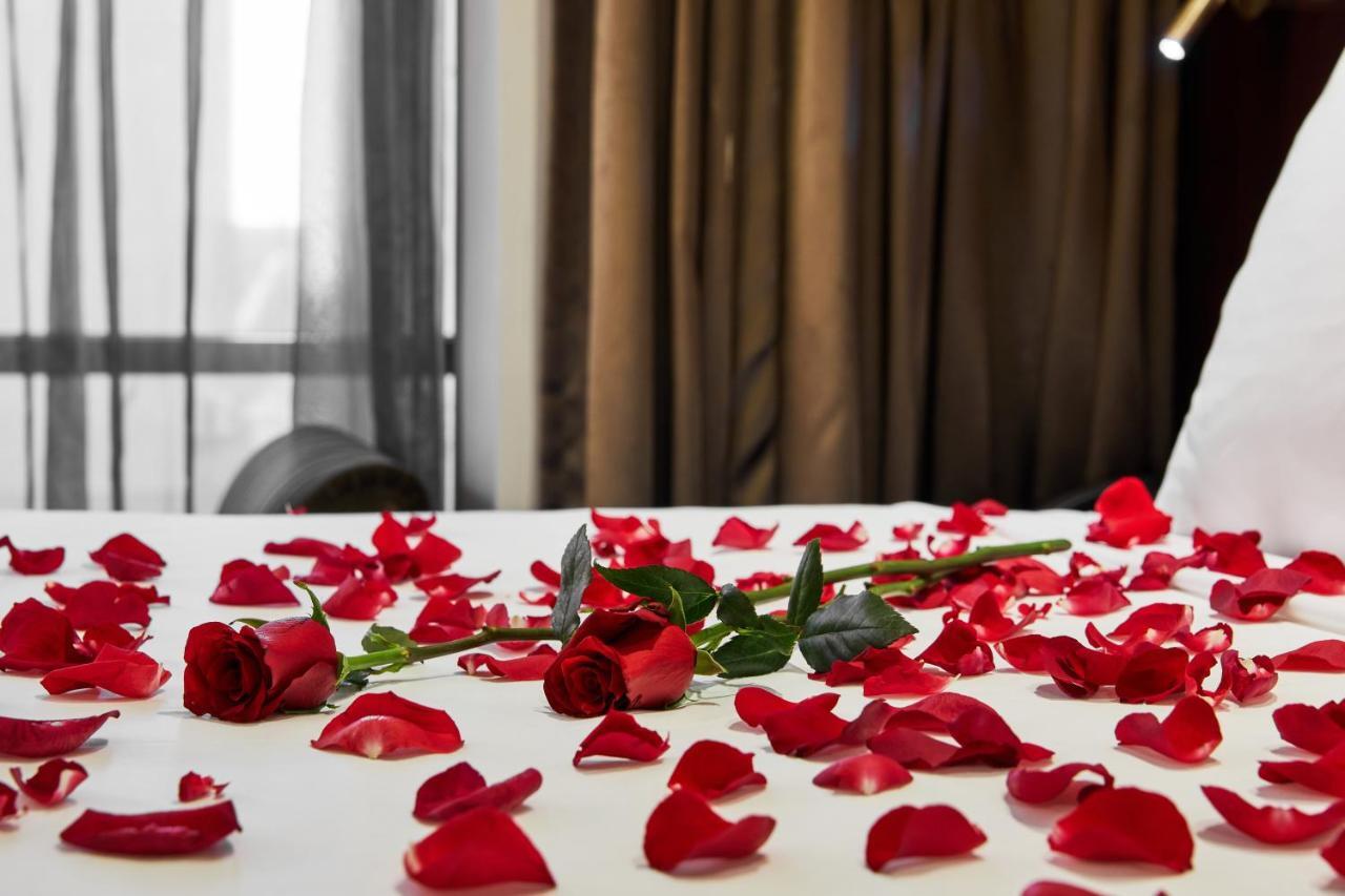 Hotel Stamford Plaza Melbourne City Exterior foto The photo shows a bed or a table covered with scattered red rose petals. Among the petals, there are a few whole red roses, still with their stems. The background features curtains that appear to be sheer, allowing some light to come through, and the